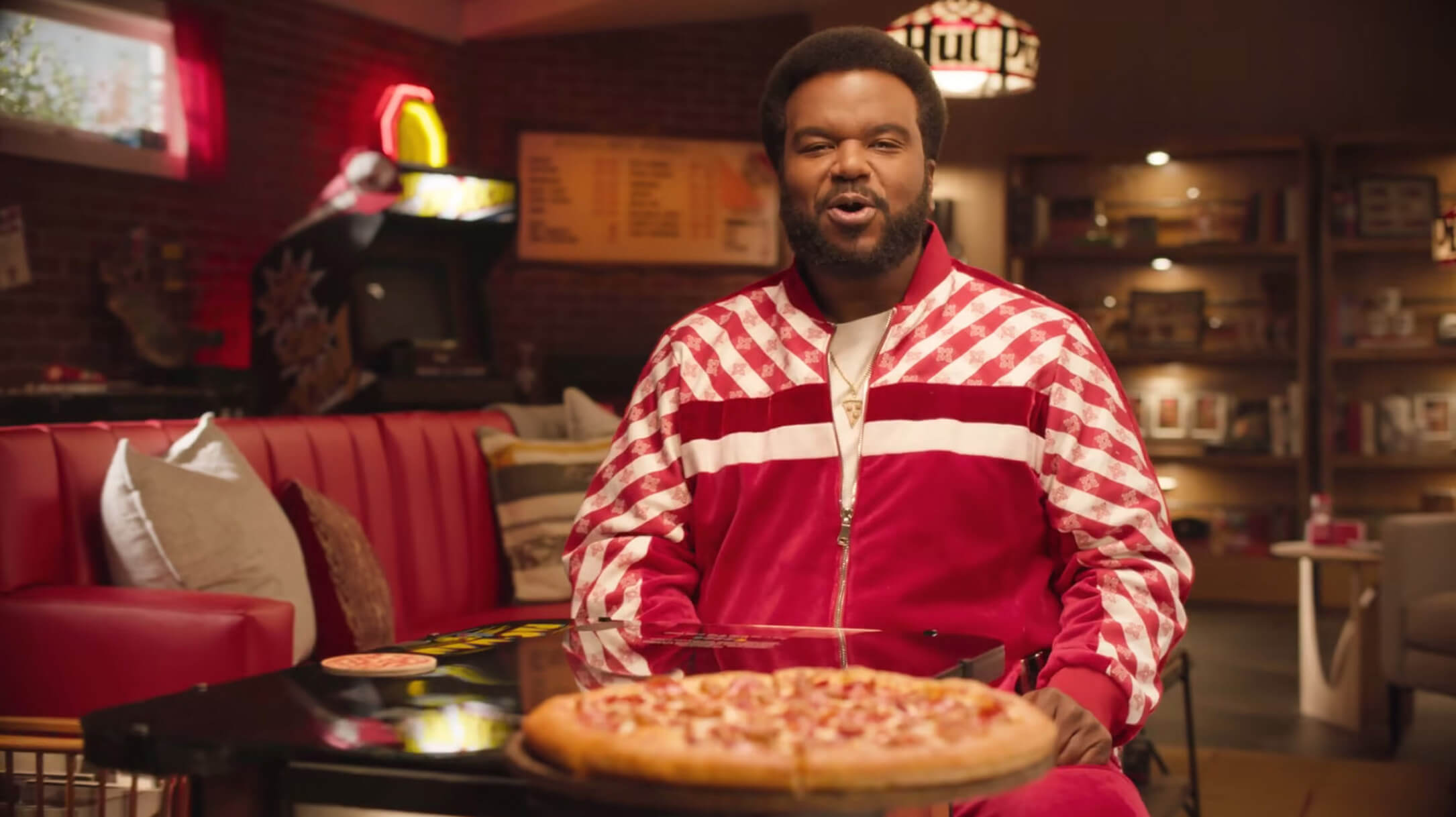 Man with pizza at Pac Man game table